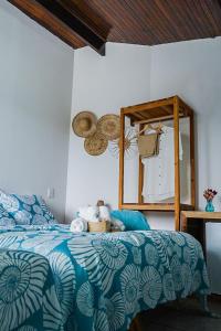 Un dormitorio con una cama azul y blanca y un espejo en Pousada Sette Mares, en Fernando de Noronha
