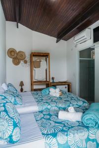 sypialnia z 2 łóżkami z niebieską i białą pościelą w obiekcie Pousada Sette Mares w mieście Fernando de Noronha