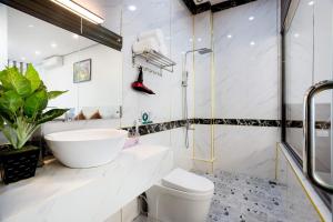 a white bathroom with a sink and a toilet at TAM COC SUNSHINE HOTEL in Ninh Binh