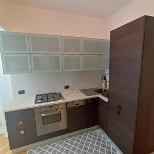 una cucina con mobili grigi e bianchi e una stufa di Appartamento Da Vinci 19 ad Alassio