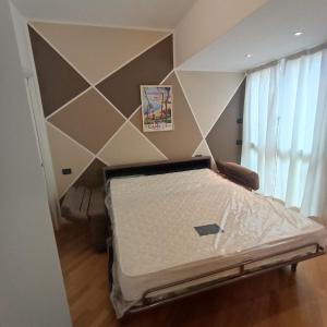 uma cama num quarto com uma parede geométrica em Appartamento Da Vinci 19 em Alassio
