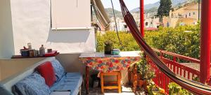 balcón con mesa y banco en TWO-BEDROOMS in GREEK VINTAGE HOME with shared Bathroom, en Korinthos