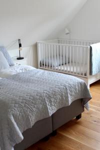 a white crib in a bedroom with a bed at Haus Strandleben in Hohwacht