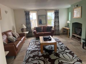 ein Wohnzimmer mit einem Sofa und einem Couchtisch in der Unterkunft Griffin Cottage in Whitby