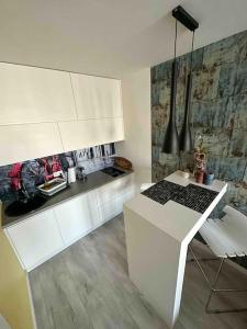 a kitchen with white cabinets and a white table at Przestronna i jasna kawalerka z balkonem in Wrocław