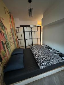 a bedroom with a black bed in a room at Przestronna i jasna kawalerka z balkonem in Wrocław