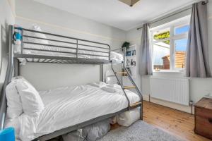 1 dormitorio con litera y ventana en Pass the Keys Little Haven A stunning Bungalow in Minnis Bay, en Birchington