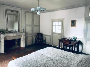 a bedroom with a bed and a desk and a mirror at les chambres fleuries in Saint-Benoît-du-Sault