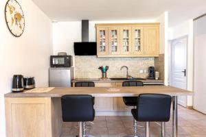 una cocina con una gran barra de madera con sillas en L'appart Gervaisien, en Saint-Gervais-la-Forêt