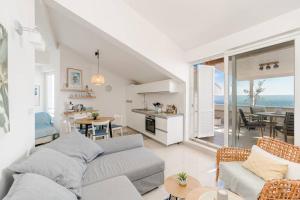 ein Wohnzimmer mit Couch und Küche mit Blick auf das Meer in der Unterkunft Sea view and More apartment in Novalja