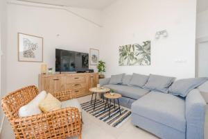 ein Wohnzimmer mit einem blauen Sofa und 2 Stühlen in der Unterkunft Sea view and More apartment in Novalja