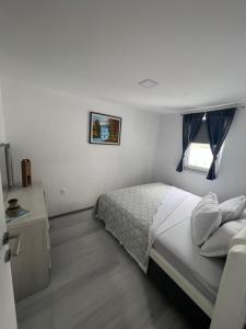 - une chambre blanche avec un lit et une fenêtre dans l'établissement Amani, à Kovačevo Polje