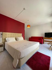 a bedroom with a white bed and a red wall at Só Mar in Vila Nova de Milfontes