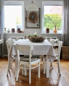 a dining room with a white table and chairs at Haus Strandleben in Hohwacht