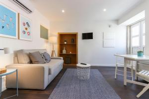 ein Wohnzimmer mit einem Sofa und einem Tisch in der Unterkunft Benfica Apartments I by Homing in Lissabon