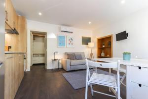 eine Küche und ein Wohnzimmer mit einem Tisch und Stühlen in der Unterkunft Benfica Apartments I by Homing in Lissabon