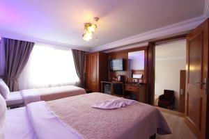 イスタンブールにあるホテル ニュー ハウスのベッド2台と鏡が備わるホテルルームです。