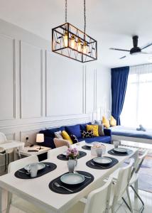 een woonkamer met een witte tafel en een blauwe bank bij Victoria Beacon Executive Suites by Bin Dao Wu Homestay Penang in George Town