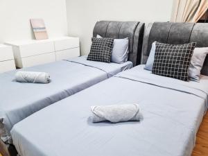 twee bedden naast elkaar in een slaapkamer bij Victoria Beacon Executive Suites by Bin Dao Wu Homestay Penang in George Town