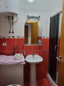 uma casa de banho com um lavatório e um espelho em Lavander em Banja Luka