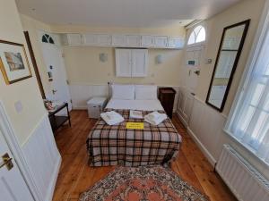 een kleine kamer met een bed en een tapijt bij Canterbury Black Horse in Canterbury