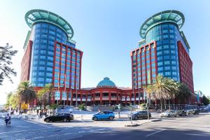 two tall buildings with cars parked in a parking lot at Benfica Apartments III by Homing in Lisbon