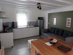 Il dispose d'une cuisine et d'un salon avec un canapé et une table. dans l'établissement Maison sud Vendée, à LʼAiguillon-sur-Mer
