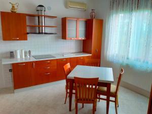 a kitchen with wooden cabinets and a table and chairs at Ca' Molino Giare 1 in Mira