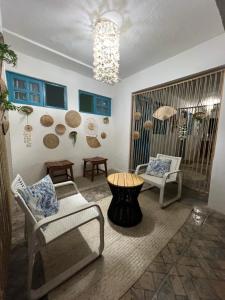 uma sala de estar com cadeiras, uma mesa e um lustre em Pousada Sette Mares em Fernando de Noronha