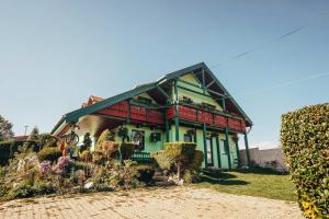 una casa verde y roja con flores delante en Penzion Ranch FAH, en Spišské Podhradie