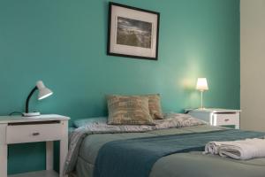 niebieska sypialnia z łóżkiem, stołem i lampką w obiekcie Los Palos Ribera Norte w mieście Playa Unión