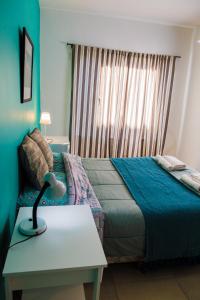 um quarto com uma cama e uma mesa com um candeeiro em Los Palos Ribera Norte em Playa Unión