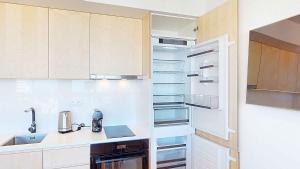 a kitchen with a sink and an empty refrigerator at Sea Nest in Portimão