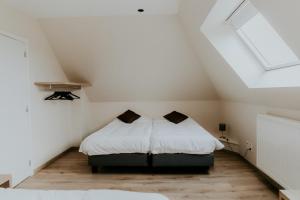Schlafzimmer im Dachgeschoss mit 2 Betten und weißer Bettwäsche in der Unterkunft Luxe Vakantiewoning De Veldhoek in Wingene