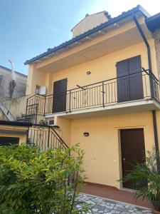 ein gelbes Haus mit Balkon an der Seite in der Unterkunft Appartamento - Il Rustico in Manerba del Garda