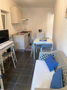 eine kleine Küche mit einem Tisch und einem Schreibtisch in der Unterkunft Appartamento - Il Rustico in Manerba del Garda