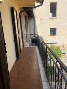 einen Balkon eines Gebäudes mit einem Gehweg aus Ziegelsteinen in der Unterkunft Appartamento - Il Rustico in Manerba del Garda