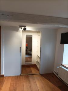 una stanza vuota con pareti bianche e pavimenti in legno di Bidi's Lodge a Stavelot