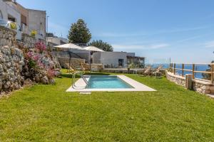 un patio trasero con una piscina en el césped en Ville Palà Luxury - Castro by HDSalento, en Castro di Lecce