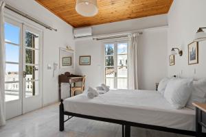 a bedroom with a large bed and a window at Villa Kalomira in Spetses