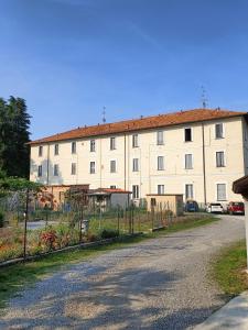 a large white building with a fence in front of it at Grazioso monolocale con soppalco al Collegio -Come a Casa Locazioni Turistiche- in Trezzo sullʼAdda