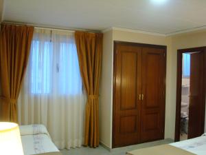 1 dormitorio con cortinas marrones y puerta en Hotel Fin De Semana, en Gandía
