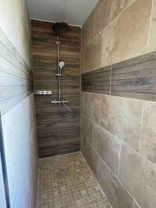 een badkamer met een douche en houten wanden bij villa 8Pers au calme avec superbe vue barbecue wifi in La Panouse