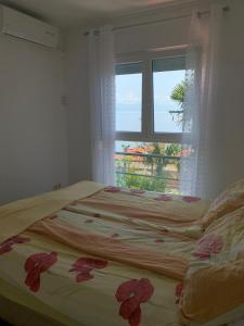 1 dormitorio con 1 cama y una ventana con flores en Apartments Diana en Opatija