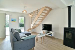 un salon avec un canapé et un escalier dans l'établissement Les Belles Noës, à Saint-Briac-sur-Mer