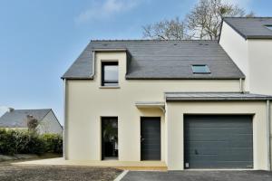 une maison blanche avec un garage dans l'établissement Les Belles Noës, à Saint-Briac-sur-Mer