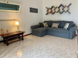 uma sala de estar com um sofá azul e uma mesa em Mamma Ciccia - Lake front apartment, beach and swimming pool em Lierna