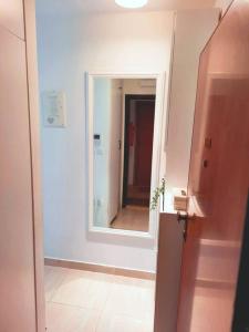 - un couloir avec un miroir dans une chambre blanche dans l'établissement Apartman Nane, à Solin