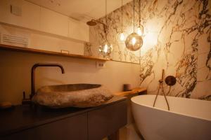 a bathroom with a large tub and a sink at The Luxury Garden Apartment in Shkodër +22 photos