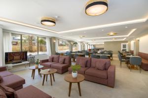 a waiting room with couches and tables and chairs at Kalyves Beach Hotel in Kalyves